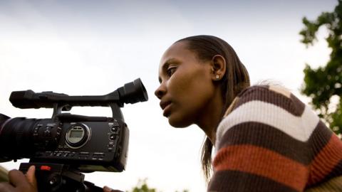 Young black woman holding a video camera
