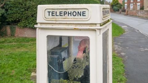 Image of a man using one of the protected phone boxes