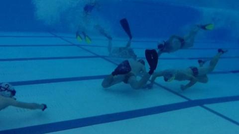 Underwater hockey players in the pool