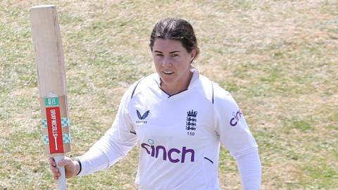 Tammy Beaumont raising her bat for a century