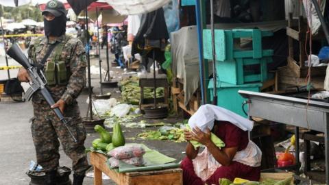 Soldiers guard a crime scene in San Salvador