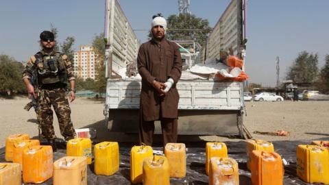 The suspect is paraded in front of the truck bomb in Kabul, 15 October