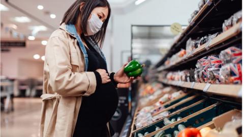 pregnant woman wearing mask in supermarket