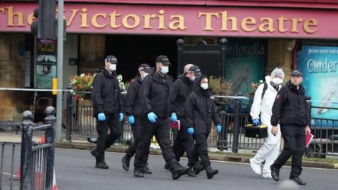 Police and forensic officers outside The Victoria Theatre near the scene of a triple stabbing in Commercial Street