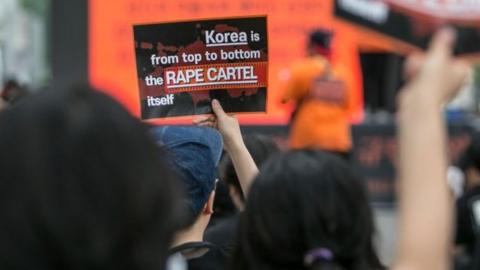 Feminists chant slogans as they hold signs that read, 'Korea is from top to bottom the Rape Cartel itself', during a rally on July 27, 2019 in Seoul, South Korea.