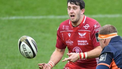 Dan Jones of Scarlets is about to be tackled by WP Nel