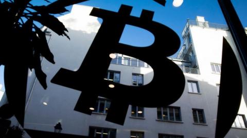 A bitcoin logo on a window at La Maison du Bitcoin in Paris
