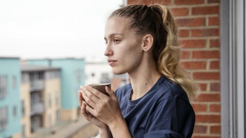 A woman drinks coffee in a new home