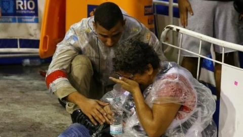 A photographer is assisted after an accident during the carnival parade at the Sambadrome in Rio de Janeiro, Brazil, February 26, 2017