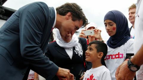 Canada's PM Trudeau shakes hands with a Syrian refugee during Canada Day celebrations