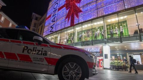 A police car is parked outside the Manor department store where the attack took place