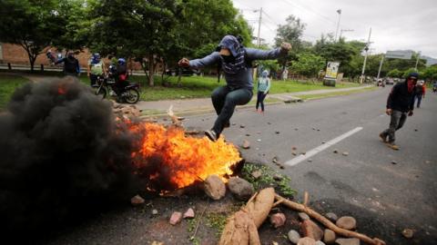 A demonstrator jumps on a barricade during a protest against the government of Honduras' President Juan Orlando Hernandez, in Tegucigalpa