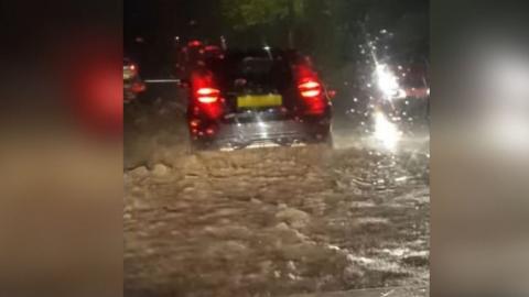 car driving on flooded road