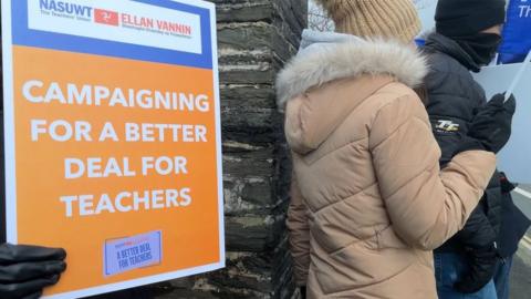 A sign being held up calling for a better deal for teachers