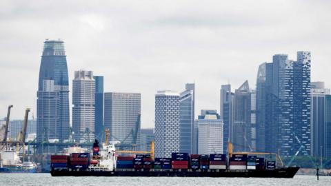 Singapore skyline and cargo ship - file pic