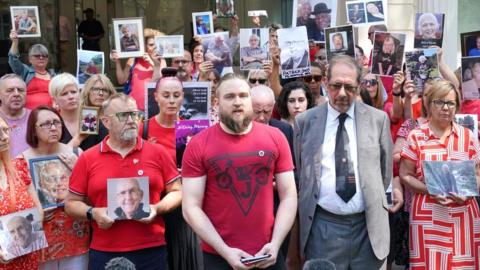 Matt Fowler (centre) co-founder of Covid Bereaved Families For Justice speaks to media outside the UK Covid-19 Inquiry at Dorland House in London which will begin hearing evidence for its first investigation (Module 1) examining if the pandemic was properly planned for and "whether the UK was adequately ready for that eventuality", 13 June 2023