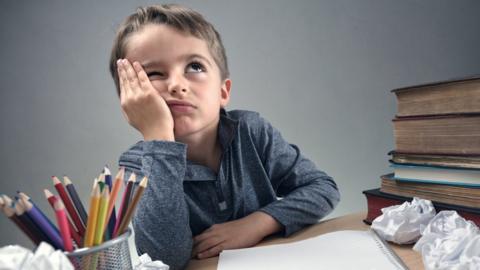 Boy looking fed up with homework