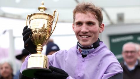 Jockey Harry Cobden with the trophy after winning the Paddy Power Gold Cup at Cheltenham with Stage Star