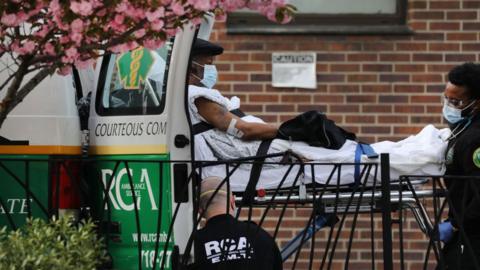 Medical workers take in patients outside of a special coronavirus intake area at a Brooklyn hospital on 14 April, 2020 in New York City