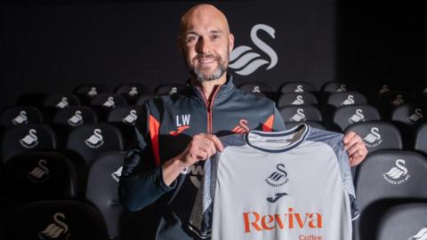 Luke Williams poses with the Swansea shirt