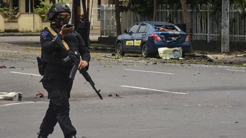 Indonesian police examine the site near a church after an explosion in Makassar