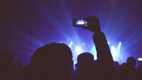 Close up of someone recording a gig on their phone