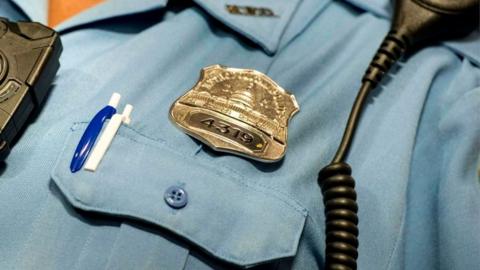 A Washington DC police officer models a body camera before a press conference at City Hall, 24 September 2014