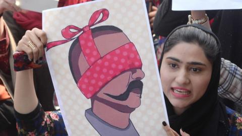 People hold depection of captured Indian Air Force Pilot Wing Commander Abhinandan, as they shout anti-India slogans during a protest in Lahore, Pakistan, 28 February 2019.