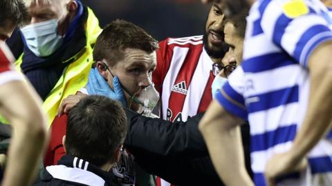 John Fleck receives treatment after collapsing on the pitch between Reading and Sheffield United