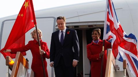 David Cameron walks down the steps of a plane as he arrives in Beijing in 2010