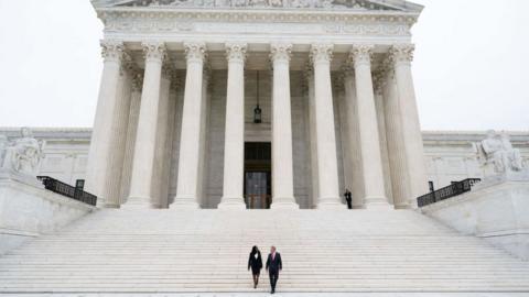 US Supreme Court Justice Ketanji Brown Jackson and Chief Justice John Roberts walk down the steps of the US Supreme Court, immediately following the investiture ceremony of Justice Jackson in Washington, DC, September 30, 2022