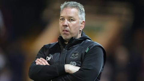 Peterborough manager Darren Ferguson watches on from the dugout during a match