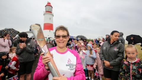 Michelle Weedy holds the baton at Souter Lighthouse