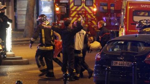 Medics move a wounded man near the Boulevard des Filles-du-Calvaire after an attack November 13, 2015 in Paris