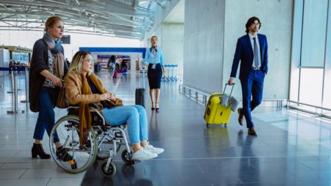 Crowd of people with luggage at international airport - stock photo