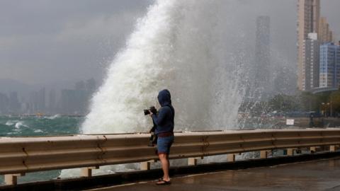 A man takes a photo on a waterfront as Typhoon Haima approaches in Hong Kong, China, 21 October 2016.