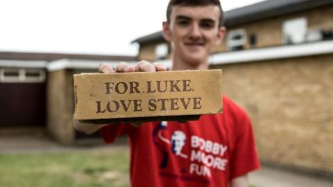 Jonjo holding one of the memorial bricks