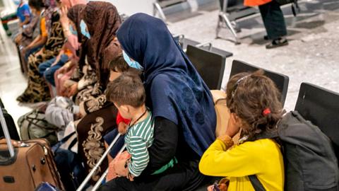 Refugees from Afghanistan wait to be processed after arriving on an evacuation flight at Heathrow Airport, in London on 26 August 2021