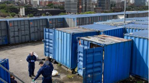 Police officers seize counterfeit goods from shipping containers