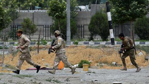 Afghan security personnel run at the scene of a suicide attack by Taliban militants on the Afghan parliament building in Kabul on 22 June 2015