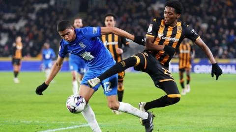 Cody Drameh of Birmingham City is challenged by Jaden Philogene-Bidace of Hull City during the Sky Bet Championship match between Hull City and Birmingham City at MKM Stadium on March 05, 2024 in Hull, England.