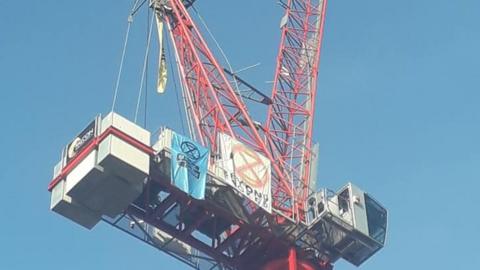 A youth protestor has scaled a crane in Norwich