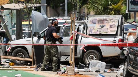 Members of Israeli security and emergency personnel work at the site of a reported car ramming attack in Tel Aviv