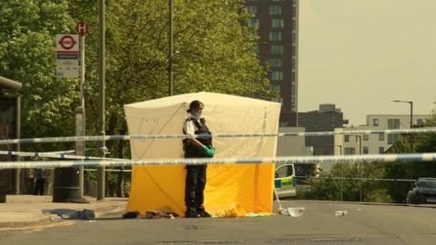 An office stands next to a white tent within a police cordon