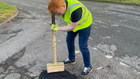 Luke Mason appearing to repair a pothole