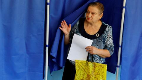 A woman walks out of a voting booth at a polling station during local elections held by the Russian-installed authorities in the course of Russia-Ukraine conflict in Donetsk, Russian-controlled Ukraine, September 8, 2023