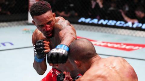 A bloodied Lerone Murphy aims a punch at Edson Barboza