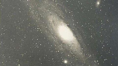 A cluster of shining  "blobs". The objects towards the centre are brightest, though dark lines block out a portion of the visible image 