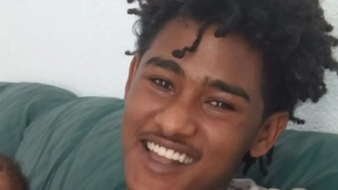 A close-up of a young man smiling towards the camera