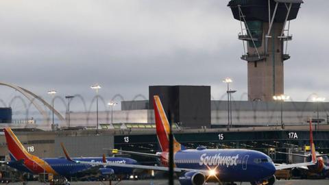 A Southwest Airlines plane taxis in front of the air traffic control tower at Los Angeles International Airport (LAX) on November 6, 2025